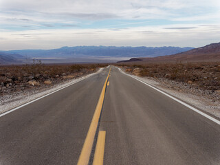 Fototapeta na wymiar Straight road in the middle of a desert landscape