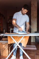 a man ironing a T-shirt at home