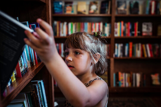 Child at library bookstore looking at books