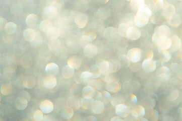 bright glitter background: bokeh effect from many colored lights on frozen glass, toning