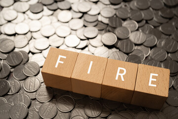 「FIRE」と書かれた積み木とコイン