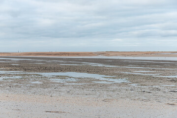 Plage pendant la marée basse. Dune de sable à l'horizon. 