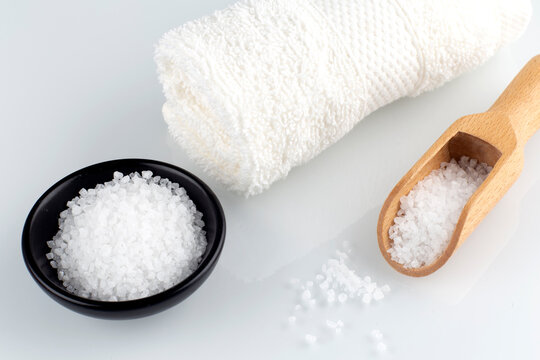 Sea salt and white towel on the white background,spa concept