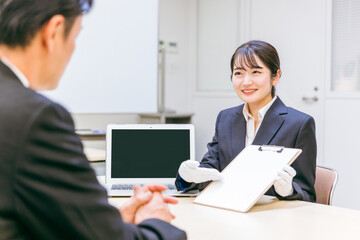 Fototapeta premium 打ち合わせする白手袋をつけたビジネスウーマン（書類） 