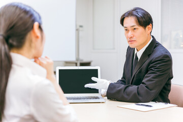 Obraz premium 打ち合わせをする白手袋をつけたビジネスマン（真剣） 