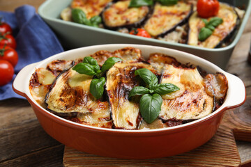 Delicious eggplant lasagna in baking dish on wooden table