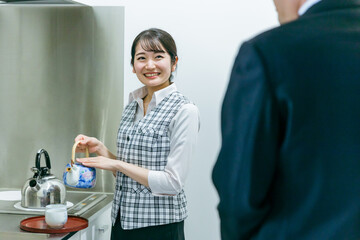 お茶をくむ会社員の女性
