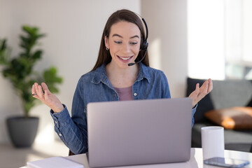 Caucasian woman at home remote working on laptop computer talking to her colleague