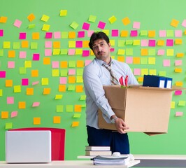 Man collecting his stuff after redundancy in the office with man