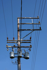 Electricity distribution pylon and power lines under blue sky