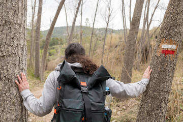 Man with backpack hiking through the forest