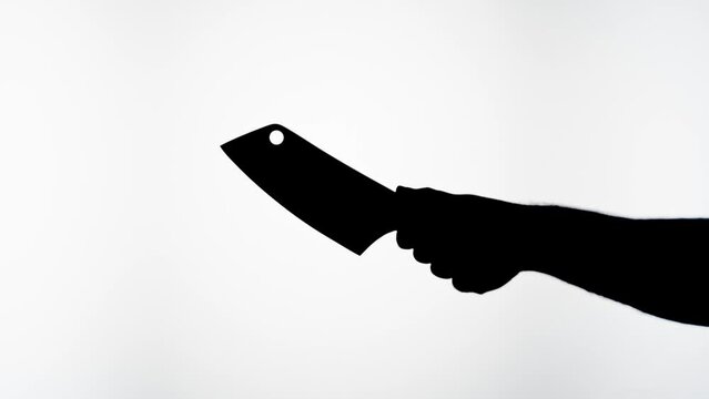 Man holding knife axe close-up, shadow silhouette of hand with weapon on white background. Horror film and killer attack. crime concept.
