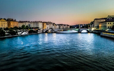 city at sunset over a river with a bridge 