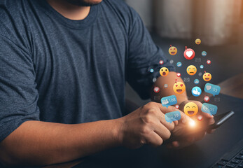 Hands holding and typing to communicate with others through emoji emotion. Online social communication,Social media,emotion, hearts. Chat Conversation on mobile. Man working using chatting application