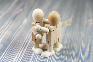Wooden figure of a man. The concept of a meeting of two close people. Hugs and love. Friendship.