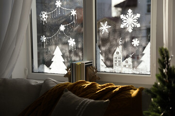 Beautiful drawing made of artificial snow on window at home. Christmas decor