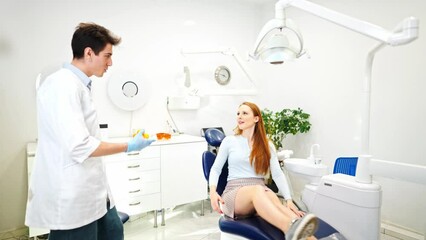 Young attractive woman visiting dentist in modern clinic for regular dental check up