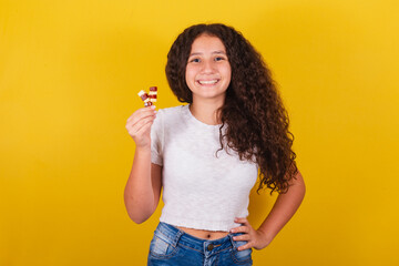 Afro brazilian, latin american, curly haired girl smiling, holding cheese and guava skewers, romeo...