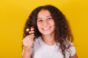 Afro brazilian, latin american, curly haired girl smiling, holding cheese and guava skewers, romeo...