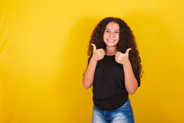Brazilian, latin american girl for afro hair, yellow background, smiling, thumbs up, ok, positive...
