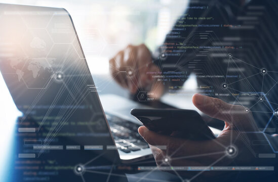 Digital software development, blockchain, internet network technology, concept. Man computer programmer, software developer working on laptop and mobile phone