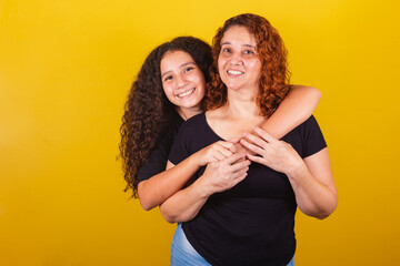 Grandmother and niece, Brazilian, Latin American, curls, afro hair, curly, smiling, hugging, family photo, beautiful. Mother's Day, Fraternity, Love. - obrazy, fototapety, plakaty