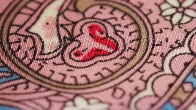 Pink silk fabric close-up, arabian design or indian pattern. Cloth texture background. Macro shooting of textile.
