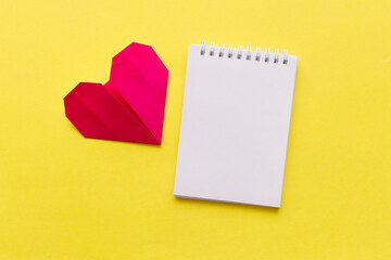 empty notebook with red heart on yellow background with space for your text