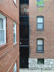 Fototapeta na wymiar Two brick apartment buildings and fire escape