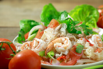 Vermicelli salad, a popular Thai salad with tomatoes, glass noodles, celery and pork. Spicy Thai food concept.