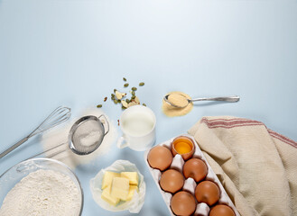 Composition of ingredients for baking on colored paper (eggs, flour, butter, nuts, milk and tools)