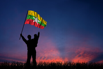Father and son hold the flag of Myanmar