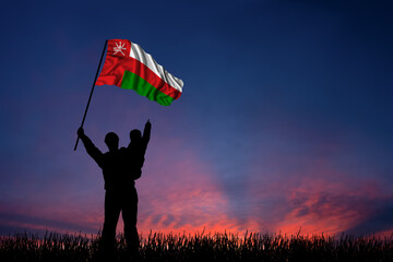 Father and son hold the flag of Oman