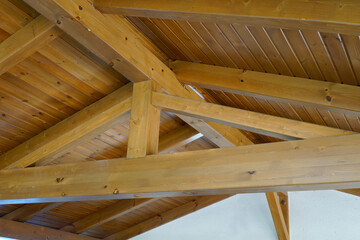 View from the inside to the rafters of the pitched roof. Wooden beams, bars and boards of the truss...