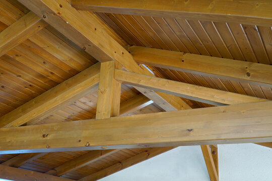 View from the inside to the rafters of the pitched roof. Wooden beams, bars and boards of the truss system.