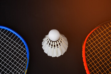 Cream white badminton shuttlecock and racket on floor in indoor badminton court, copy space, soft and selective focus on shuttlecocks.