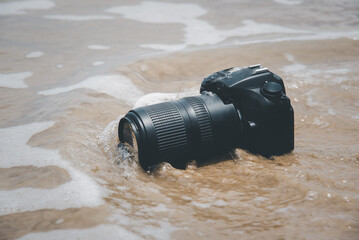 DSLR camera on beach wet from water sea wave