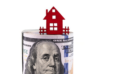 Wooden symbolic house and 100 American dollars on a white background