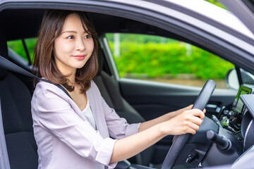 Obraz na płótnie Canvas 車を運転する若い女性