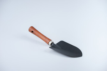 A black shovel with wooden handle on white background.
