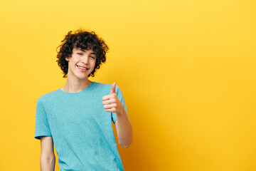 Cheerful guy showing thumb up copy-space yellow background