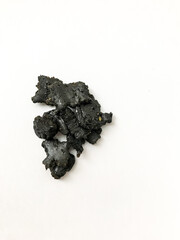 Dark incense resin on a white background, aroma background of small pieces of resin