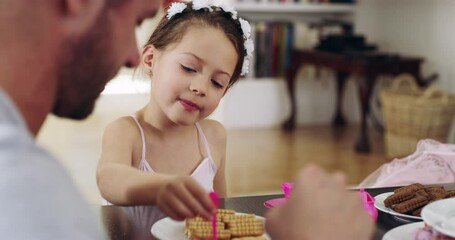 Daddys my guest of honour in todays royal tea party. 4k video footage of a father and his little daughter having a tea party together at home.