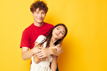 young boy and girl Friendship posing hugs together yellow background unaltered