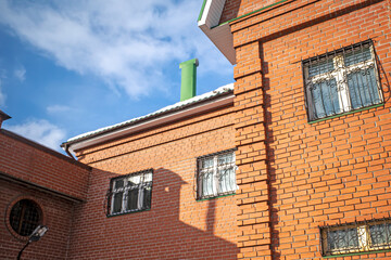 Fragment of the facade of a brick building on a winter day