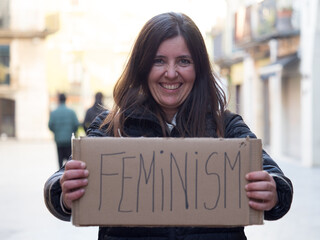 Woman in the street in protest with a poster of feminism