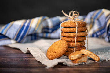 Homemade cookies with chocolate, nuts and coffee beans on a light wooden background with a linen napkin with a background blur.