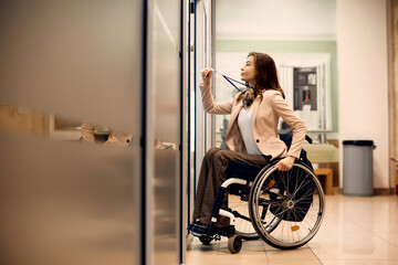 Fototapeta na wymiar Young handicapped businesswoman uses access card to enter the office.