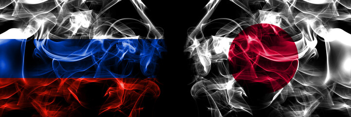 Russia, Russian vs Japan, Japanese flags. Smoke flag placed side by side isolated on black background