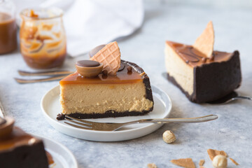 Slice of cheesecake with caramel sauce, concrete background, closeup view. Salted caramel sauce poured on cheesecake